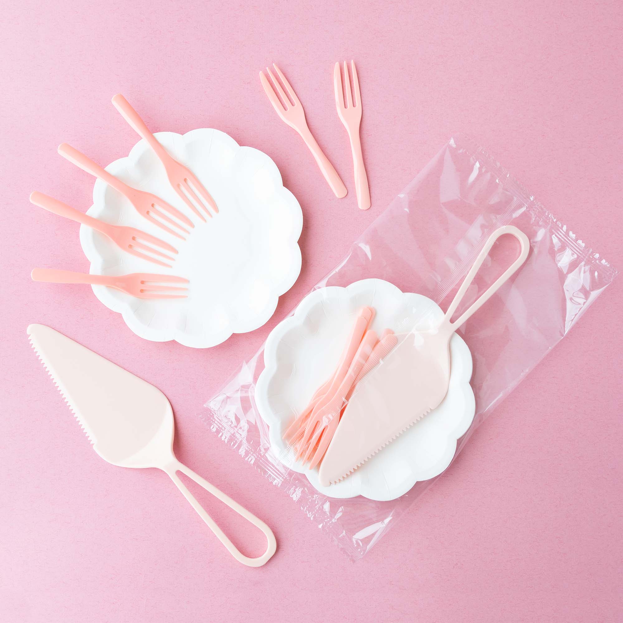 white flower cake paper plates with cake forks and cake knives